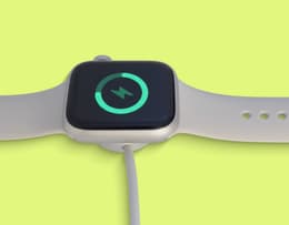 The Apple Watch 11 charging with the screen on.