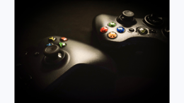 2 xbox controllers in a dark background